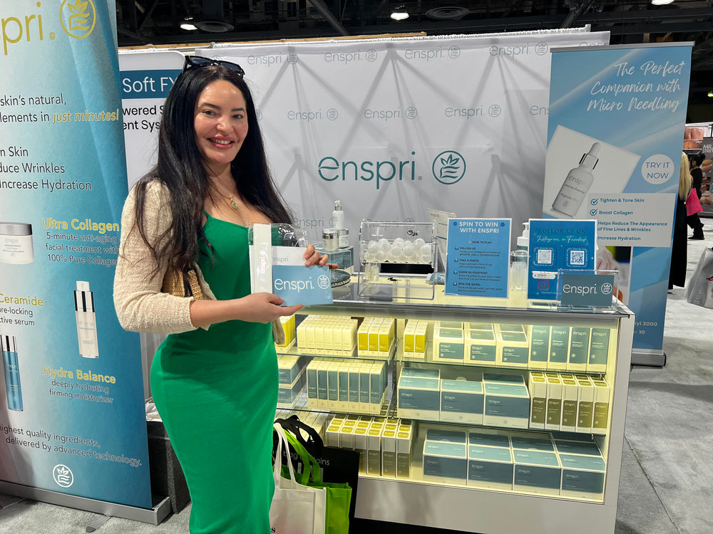 Woman standing next to Enspri's Trade Show Booth at Long Beach 2025